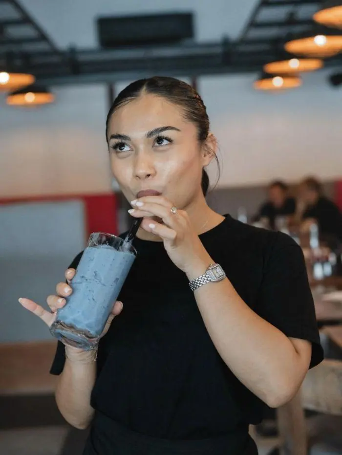 Guest enjoying an iced blue drink at Melbourne café Phuket